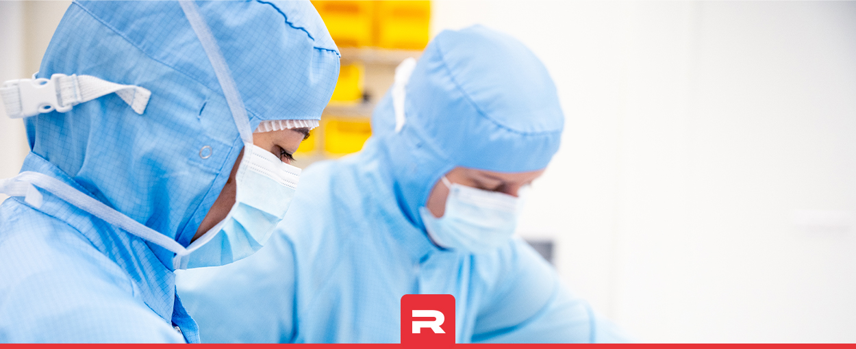 Two employees in blue cleanroom garments assembling single-use systems in Romynox’s ISO 7 cleanroom.